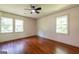 Light filled bedroom features hardwood floors, two windows, and a ceiling fan at 3219 W Manor Ln, Atlanta, GA 30311
