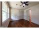A bright bedroom with hardwood floors, natural light, closet, and ceiling fan at 3219 W Manor Ln, Atlanta, GA 30311