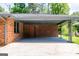 A covered carport with brick walls and gray flooring, offering a sheltered parking space at 3219 W Manor Ln, Atlanta, GA 30311