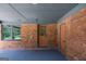 A covered carport with brick walls and gray flooring, providing sheltered parking and entry to the home at 3219 W Manor Ln, Atlanta, GA 30311