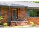 Charming front entrance featuring a brick facade, gray shutters, and meticulously maintained landscaping at 3219 W Manor Ln, Atlanta, GA 30311