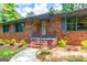 Inviting front entrance with a brick walkway, gray shutters, and meticulously maintained landscaping at 3219 W Manor Ln, Atlanta, GA 30311