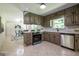 Well-lit kitchen featuring updated appliances, light countertops, and tiled flooring at 3219 W Manor Ln, Atlanta, GA 30311