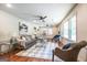 Spacious living room showcases hardwood floors, large windows, modern decor, and comfortable seating at 3219 W Manor Ln, Atlanta, GA 30311