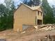 Unfinished two-story home with unfinished siding and garage on a lot with natural surroundings at 116 Deer Xing, Temple, GA 30179