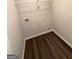 An organized laundry area with hardwood floors and overhead shelving provides efficient space at 116 Deer Xing, Temple, GA 30179