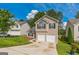 View of a two-story home featuring a two-car garage, arched windows, and a spacious driveway at 2635 Carolina Rdg, Riverdale, GA 30296