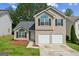 Charming two-story home with a two-car garage, arched windows, and black shutters at 2635 Carolina Rdg, Riverdale, GA 30296