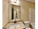 Bathroom view of the vanity and commode with large mirror and stone counter at 513 Cherry Creek Dr, Loganville, GA 30052