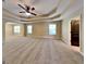 Spacious bedroom with tray ceilings, carpeted floors, natural light, and an arched entry at 513 Cherry Creek Dr, Loganville, GA 30052