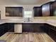 Well-lit kitchen with stainless steel appliances, dark wood cabinets, and ample counter space at 513 Cherry Creek Dr, Loganville, GA 30052