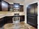 Modern kitchen with stainless steel appliances, dark cabinetry, and sleek countertops at 513 Cherry Creek Dr, Loganville, GA 30052
