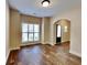 Well-lit living room featuring hardwood floors, a large window, and a stylish archway at 513 Cherry Creek Dr, Loganville, GA 30052