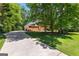 Spacious driveway leading to a charming brick home with a well-maintained lawn and lush greenery at 423 Holly Grove Church Rd, Peachtree City, GA 30269