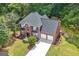 Aerial view of a brick two-story home with a well-manicured lawn and a two car garage at 1028 Gloria Grand Blvd, Mcdonough, GA 30252