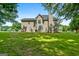 A spacious backyard with lush green grass, mature trees, and a large patio area at 1028 Gloria Grand Blvd, Mcdonough, GA 30252