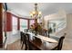 Elegant dining room with chandelier, bay window, and view into the foyer with stairs at 1028 Gloria Grand Blvd, Mcdonough, GA 30252