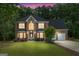 Elegant two-story brick home with lush landscaping and a well-manicured lawn at sunset at 1028 Gloria Grand Blvd, Mcdonough, GA 30252