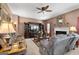 Cozy living room with a ceiling fan, fireplace, mounted TV, and comfortable seating at 1028 Gloria Grand Blvd, Mcdonough, GA 30252
