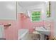 Bathroom featuring pastel pink tiles, a bathtub, and modern fixtures at 1070 Elaine Dr, Forest Park, GA 30297