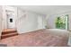 Spacious living room featuring plush carpeting, a sliding door, and staircase at 4448 Janice Dr, Snellville, GA 30039