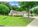 Exterior home view with beautiful lawn, mature trees, stone accents, and attached two-car garage at 140 Rehobeth Way, Fayetteville, GA 30214