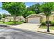View of home showcasing the two-car garage, manicured lawn, and mature trees in a neighborhood setting at 140 Rehobeth Way, Fayetteville, GA 30214
