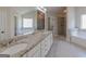 Bathroom with double vanity, granite counters, white cabinets, soaking tub, and glass shower at 236 Villa Grande Dr, Locust Grove, GA 30248
