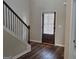Entryway featuring beautiful hardwood floors, stairway with dark handrail, and a door with built-in blinds at 236 Villa Grande Dr, Locust Grove, GA 30248