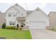 Charming two-story home with an attached two car garage and manicured lawn at 236 Villa Grande Dr, Locust Grove, GA 30248