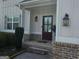 Close-up shot of the home's front entrance shows the details of the brick base and updated door and sconces at 236 Villa Grande Dr, Locust Grove, GA 30248