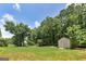 Lush backyard featuring mature trees and a shed, offering a private and serene outdoor space at 35 Deep Springs Way, Covington, GA 30016