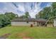 Back of the property with covered patio, grill, and swing set in a large green yard at 527 Malcom Rd, Covington, GA 30014