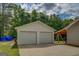 Spacious detached two-car garage with a concrete driveway and adjacent covered area at 527 Malcom Rd, Covington, GA 30014