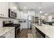 Open kitchen features stainless steel appliances, granite countertops and white cabinetry at 3018 Patriots Square, Marietta, GA 30064