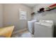 Functional laundry room with washer, dryer, storage shelves, and a folding table at 3018 Patriots Square, Marietta, GA 30064