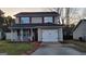 Charming two-story home features red accents, a front porch, and attached one-car garage at 1611 Cobbs Creek Ln, Decatur, GA 30032