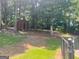 View of the tree lined backyard with a shed and a grassy hill at 4489 Northwind Dr, Ellenwood, GA 30294