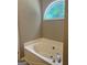 Relaxing bathroom featuring a soaking tub with natural light from an arched window at 4489 Northwind Dr, Ellenwood, GA 30294