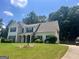 Traditional two-story home featuring a lush lawn, landscaping, and a classic design with a timeless aesthetic at 4489 Northwind Dr, Ellenwood, GA 30294