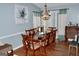 Formal dining room with hardwood floors, decorative chandelier, and seating for eight at 3253 Blackfoot Ln, Rex, GA 30273