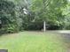 Picturesque backyard featuring mature trees and lush green grass at 2039 Faith Cv, Atlanta, GA 30349