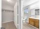 Walk-in closet next to bathroom features a small window and a shelving system at 2039 Faith Cv, Atlanta, GA 30349