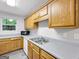 This kitchen features wood cabinets, gray counters, stainless steel sink, and a window for natural light at 2039 Faith Cv, Atlanta, GA 30349