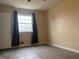 This bedroom offers natural light from a large window and modern, gray wood-look flooring at 5793 Springfield Pl, Ellenwood, GA 30294