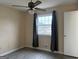 This bedroom offers natural light from a large window and modern, gray wood-look flooring at 5793 Springfield Pl, Ellenwood, GA 30294