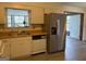 Well-lit kitchen with a stainless steel refrigerator and a view into the sunroom at 5793 Springfield Pl, Ellenwood, GA 30294