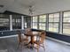 Sunroom with a wooden dining table, three chairs, and lots of natural light at 5793 Springfield Pl, Ellenwood, GA 30294