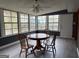Enclosed sunroom featuring a round dining table, 3 chairs and large windows at 5793 Springfield Pl, Ellenwood, GA 30294