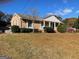 A charming brick house featuring white columns and shutters on a partially sunny day at 6099 Winview Dr, Forest Park, GA 30297